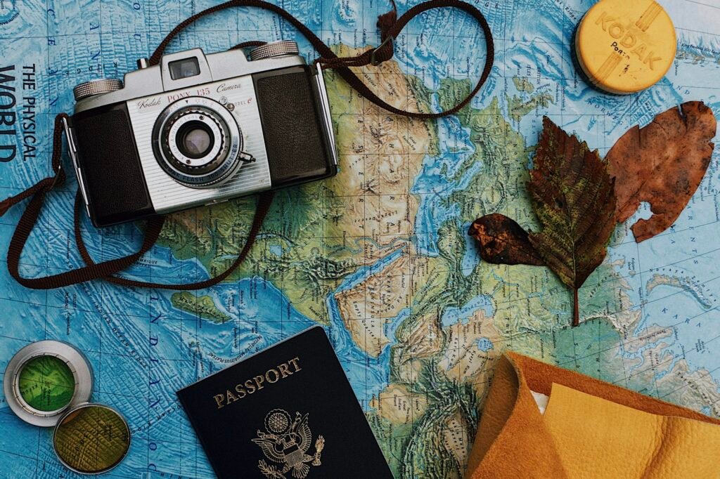 Passport, laptop and camera laid out while planning a trip